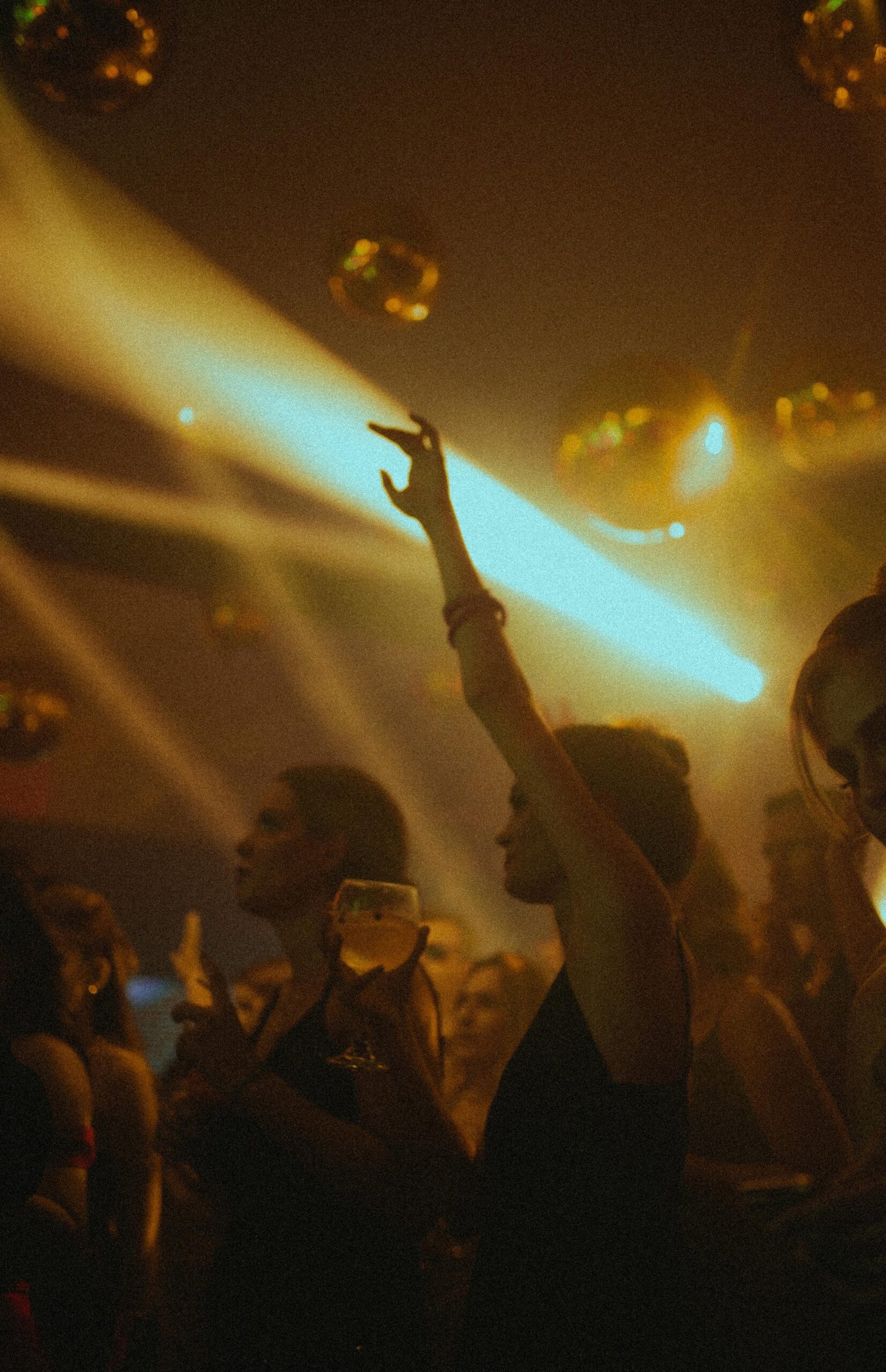 Vibrant nightclub scene with people dancing under colorful lights, capturing the lively atmosphere.